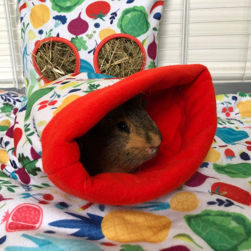 A ginger guinea pig inside of red veggie sleep sack on top of kavee fleece liner