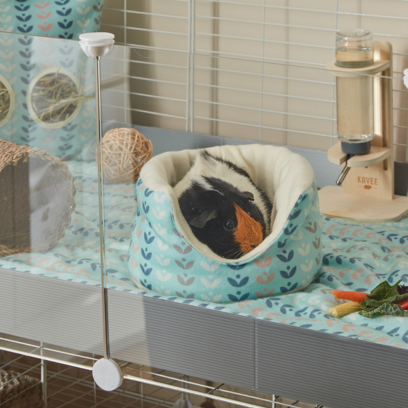 A tri coloured guinea pig inside of a kavee scandi abstact cuddle cup on top of fleece liner